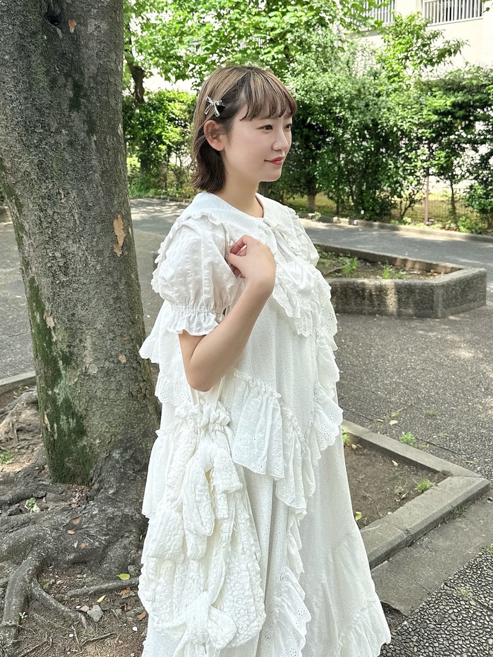 ホワイト系のシャツ/ブラウス、ホワイト系のサンダル、ホワイト系のトートバッグを着用したレディースの春コーディネートの5枚目の写真