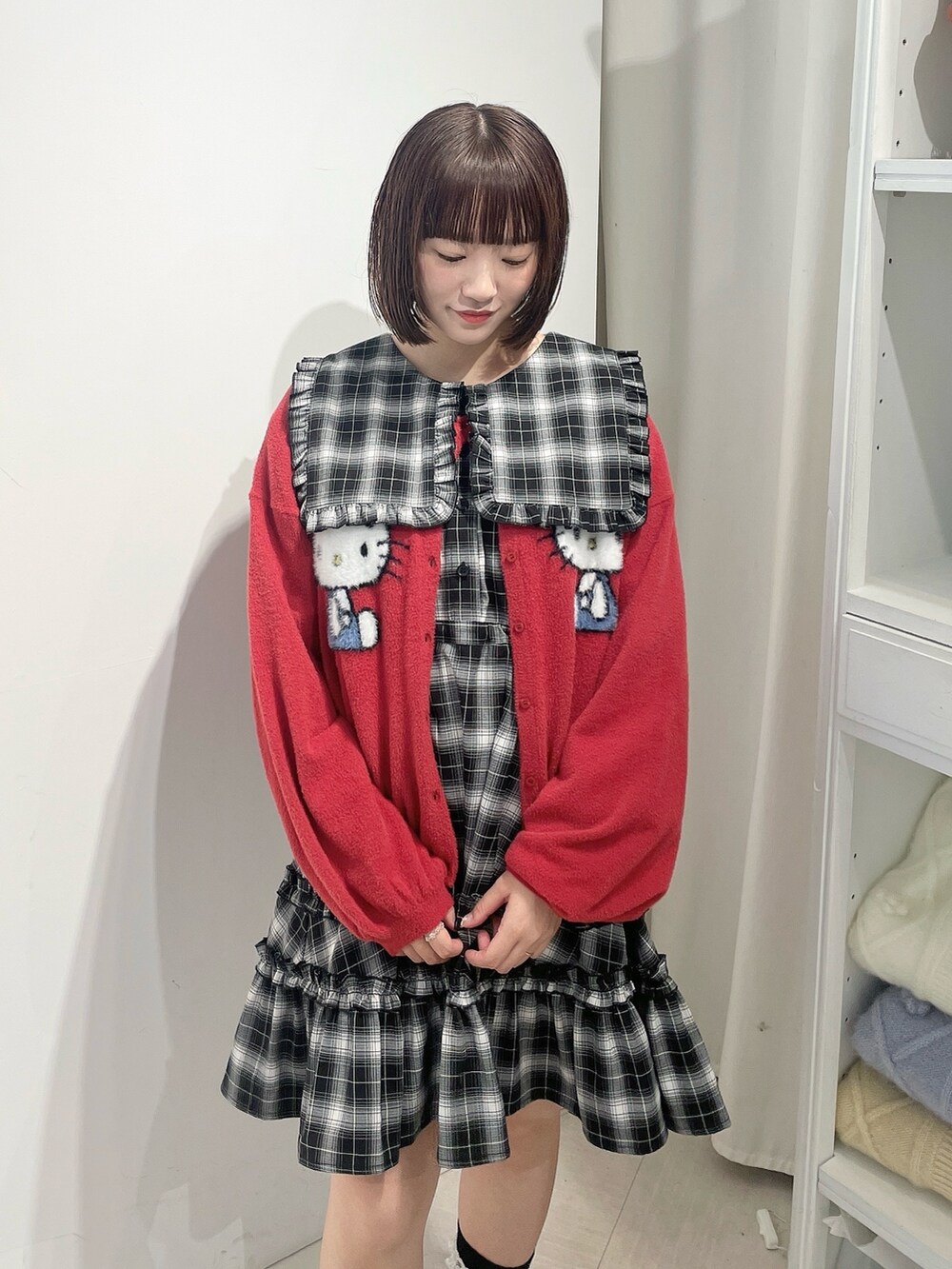 ブラック系のワンピース、レッド系のカーディガン/ボレロ、ブラック系のローファーを着用したレディースの秋コーディネートの5枚目の写真