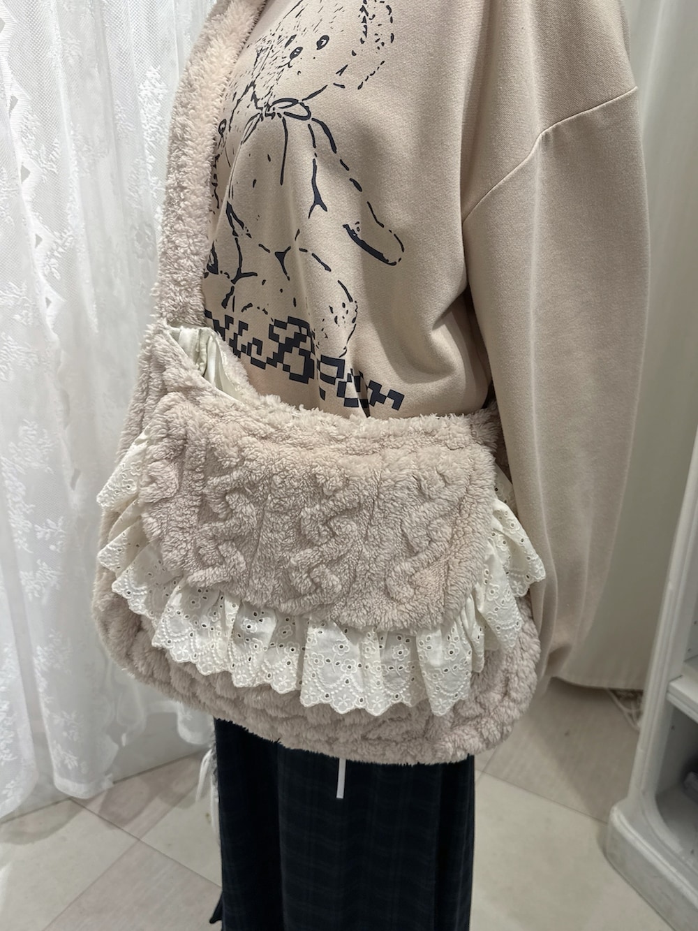 ベージュ系のスウェット、ベージュ系のショルダーバッグ、グリーン系のスカートを着用したレディースの秋コーディネートの7枚目の写真