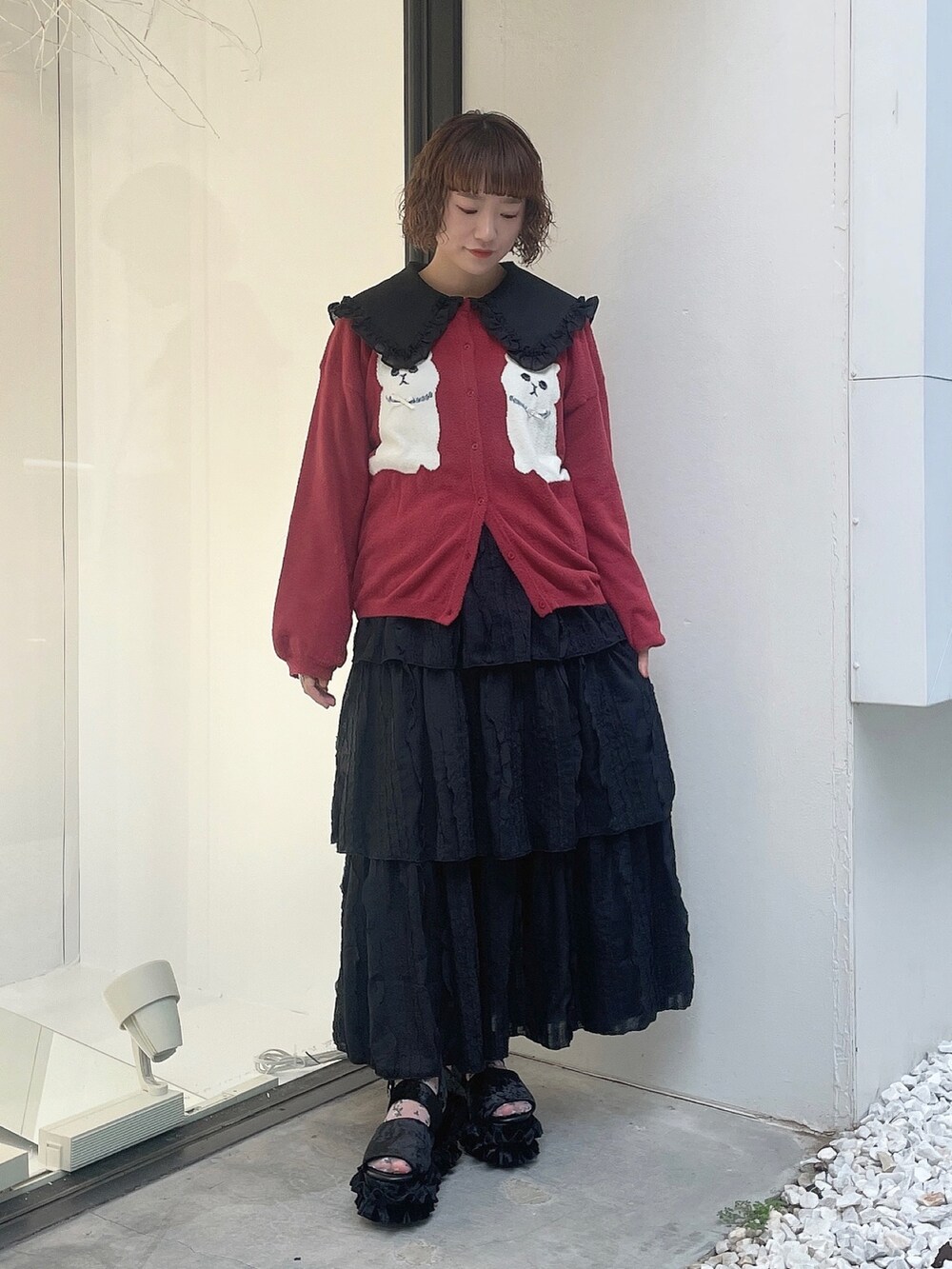 ブラック系のスカート、ブラック系のサンダル、レッド系のカーディガン/ボレロを着用したレディースの夏コーディネートの2枚目の写真