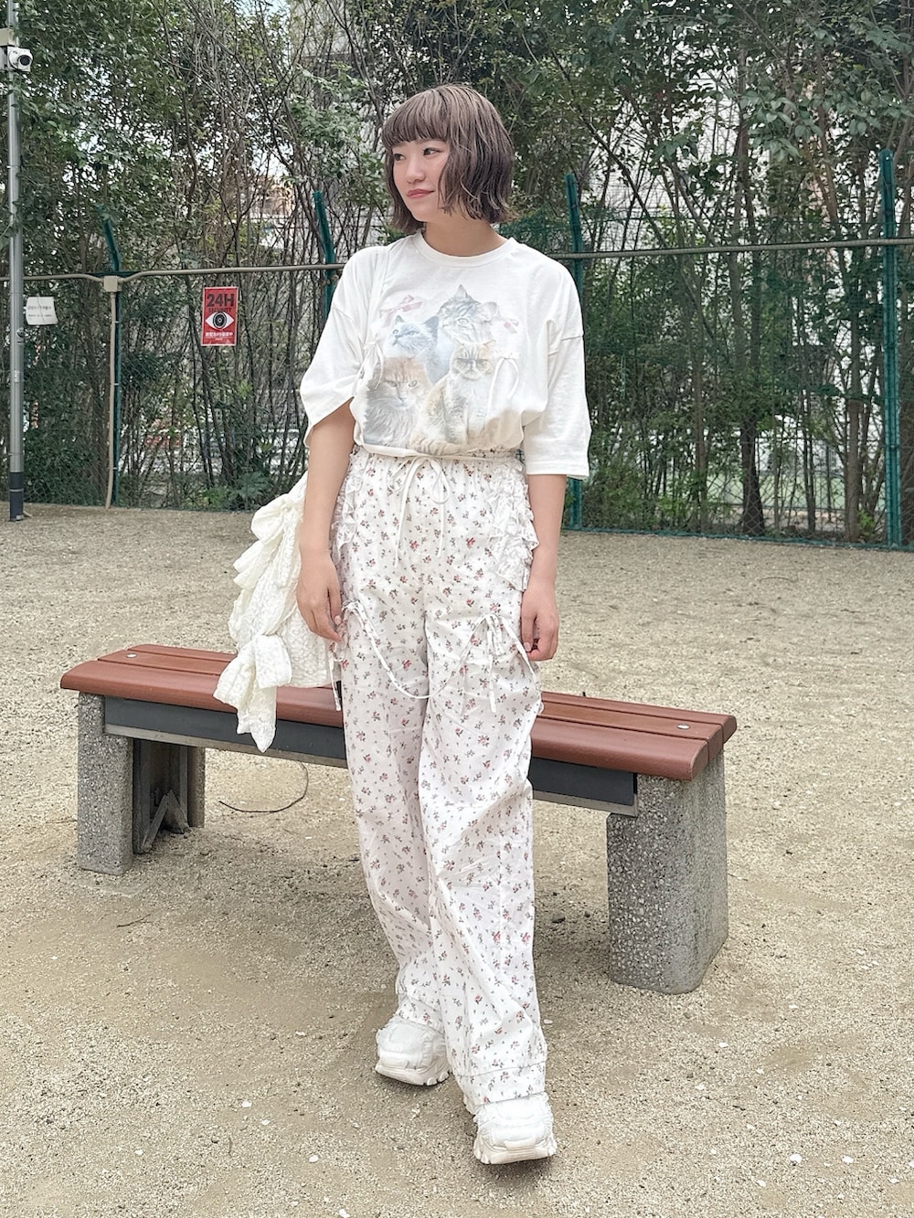 ホワイト系のTシャツ/カットソー、ホワイト系のスラックス、ホワイト系のトートバッグを着用したレディースの春コーディネートの4枚目の写真