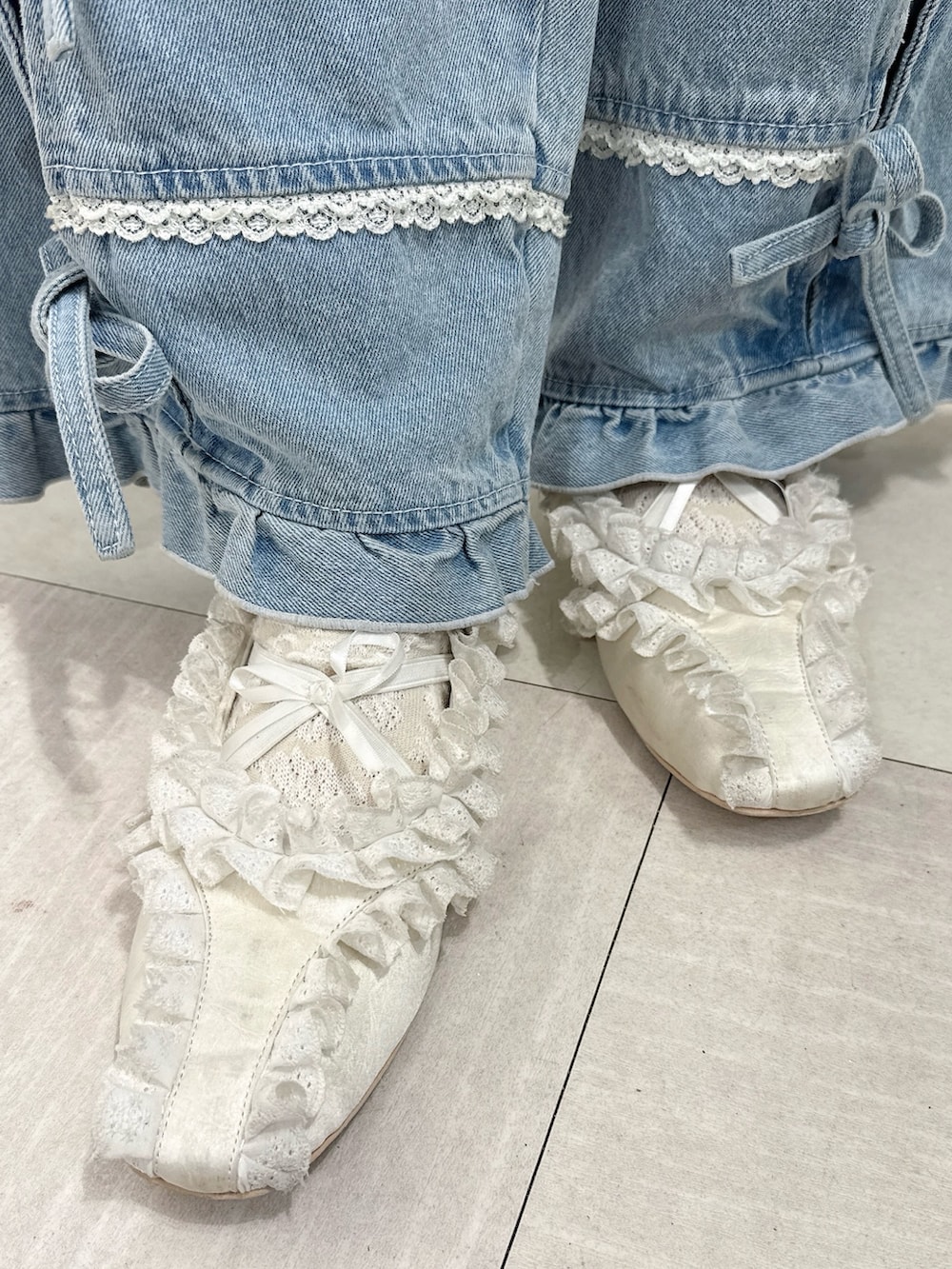 ホワイト系のワンピース、グレー系のTシャツ/カットソー、ブルー系のデニムパンツを着用したレディースの春コーディネートの8枚目の写真