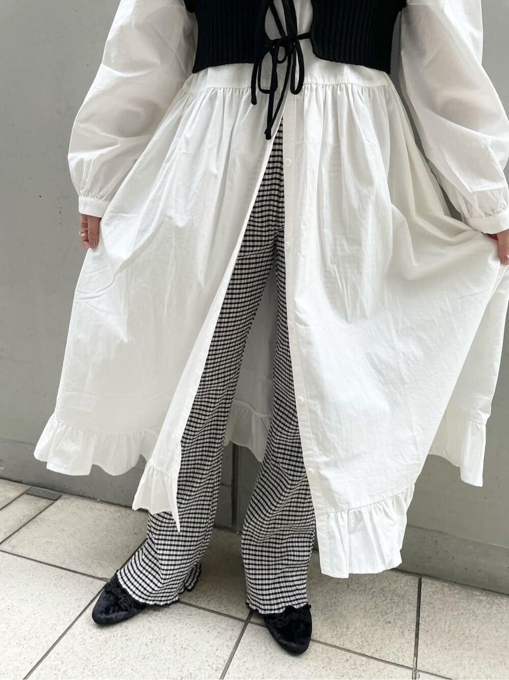 ブラック系のニット/セーター、ブラウン系のワンピース、ブラック系のその他パンツを着用したレディースの秋コーディネートの9枚目の写真