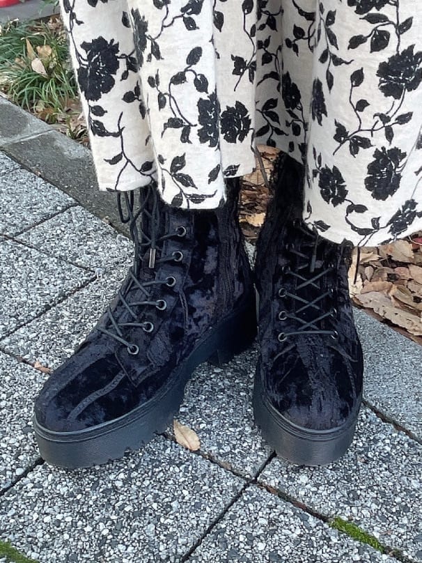 ブラック系のブーツ、ブラック系のナイロンジャケット、ホワイト系のジャンパースカートを着用したレディースの冬コーディネートの7枚目の写真