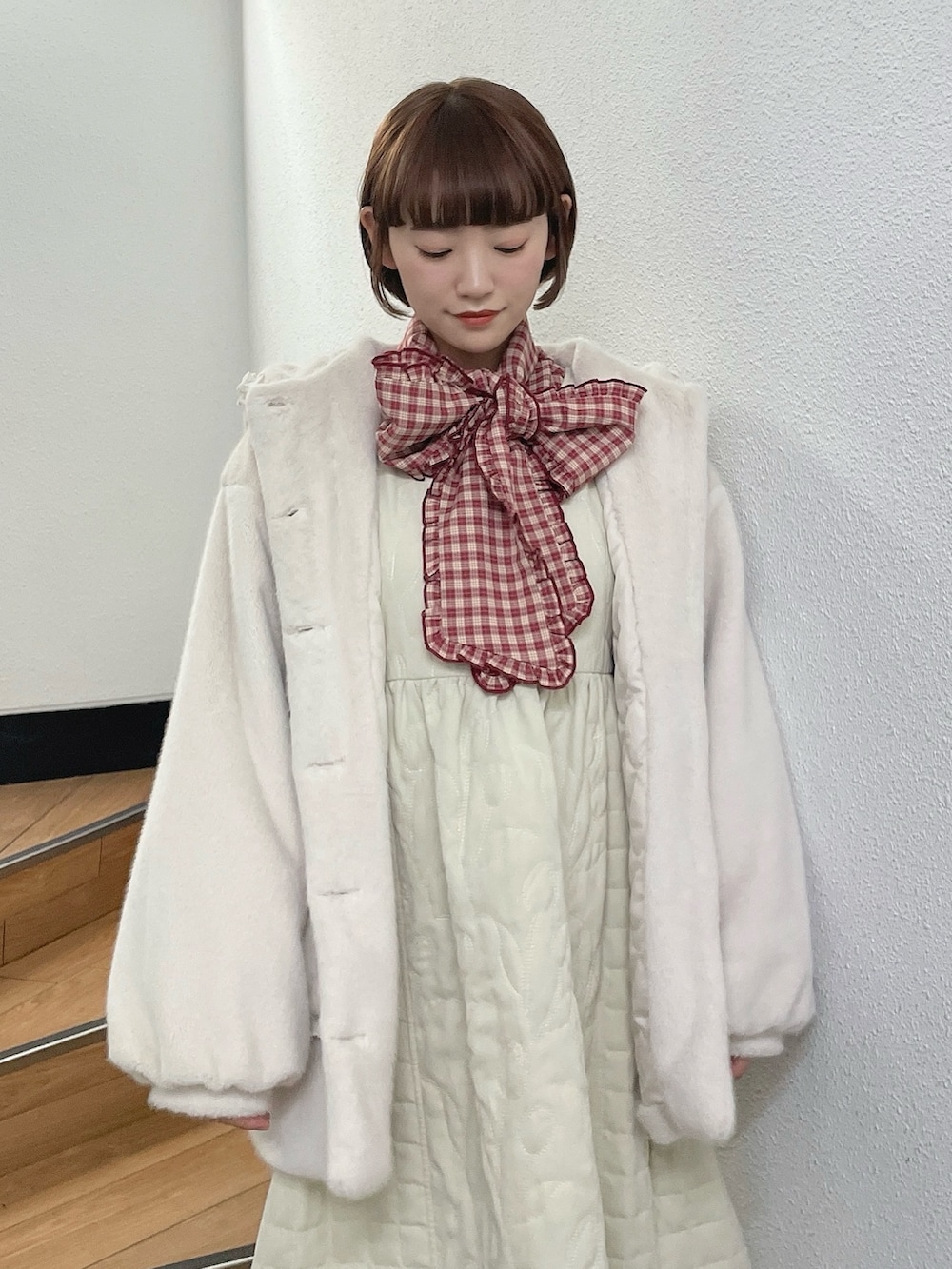 ホワイト系のダウンジャケット/コート、レッド系のシャツ/ブラウス、ホワイト系のワンピースを着用したレディースの冬コーディネートの5枚目の写真