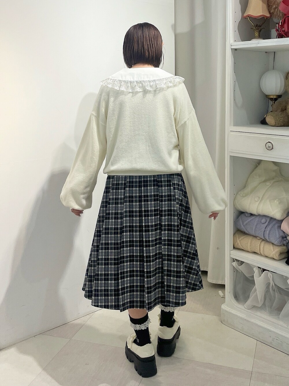 ホワイト系のカーディガン/ボレロ、シルバー系のシャツ/ブラウス、ブラック系のスカートを着用したレディースの秋コーディネートの3枚目の写真