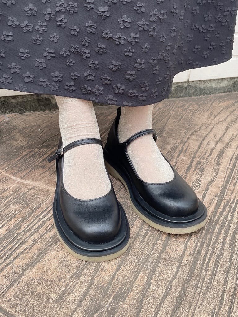 ブラック系のワンピース、ブラック系のパンプス、ホワイト系のニット/セーターを着用したレディースの秋コーディネートの7枚目の写真