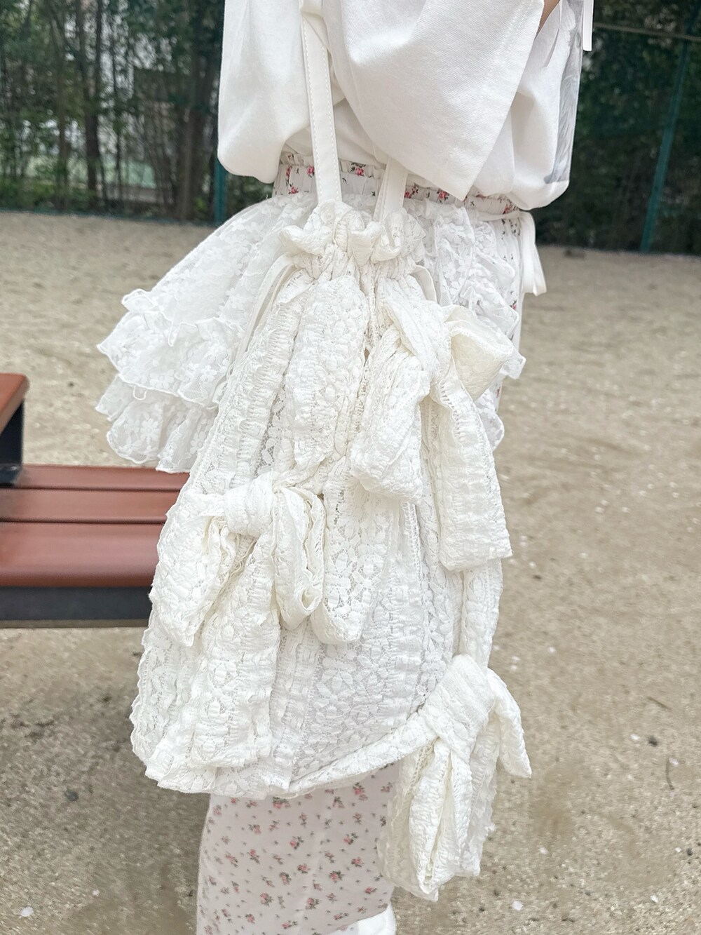 ホワイト系のTシャツ/カットソー、ホワイト系のスラックス、ホワイト系のトートバッグを着用したレディースの春コーディネートの6枚目の写真