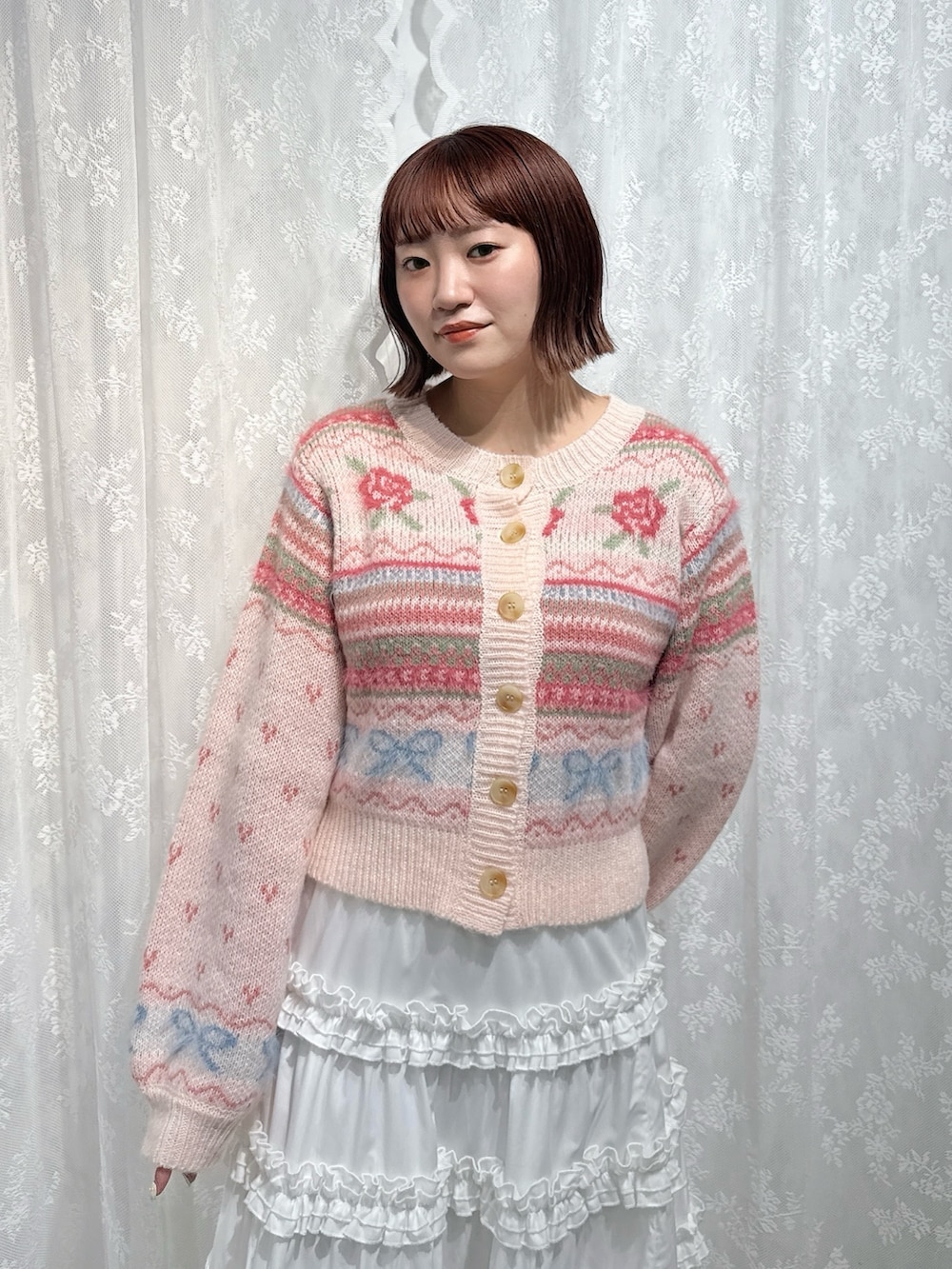 ピンク系のカーディガン/ボレロ、ホワイト系のスカート、ブラウン系のハンドバッグを着用したレディースの夏コーディネートの5枚目の写真