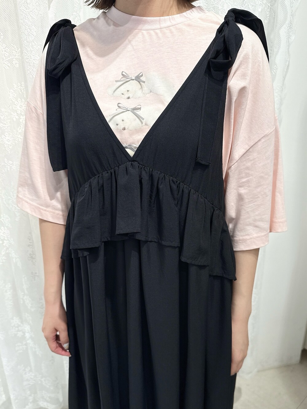 ピンク系のTシャツ/カットソー、ブラック系のワンピース、ブラック系のサンダルを着用したレディースの春コーディネートの6枚目の写真