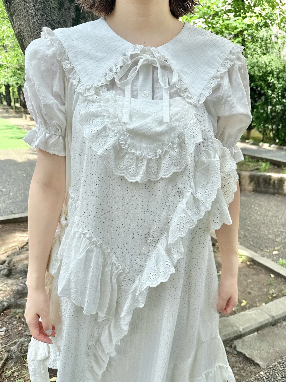 ホワイト系のシャツ/ブラウス、ホワイト系のサンダル、ホワイト系のトートバッグを着用したレディースの春コーディネートの7枚目の写真