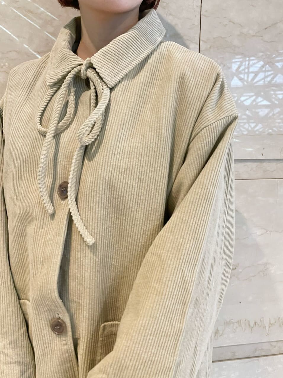 レッド系のワンピース、ブラック系のその他シューズ、ベージュ系のステンカラーコートを着用したレディースの秋コーディネートの4枚目の写真