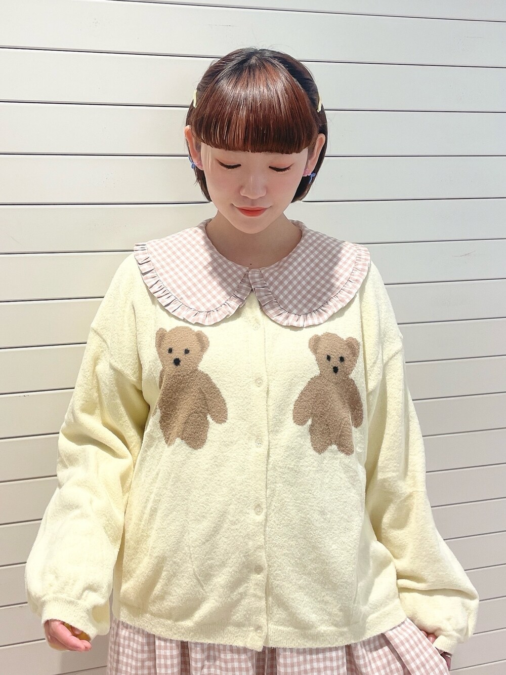 ピンク系のワンピース、ホワイト系のカーディガン/ボレロ、ホワイト系のスニーカーを着用したレディースの冬コーディネートの5枚目の写真