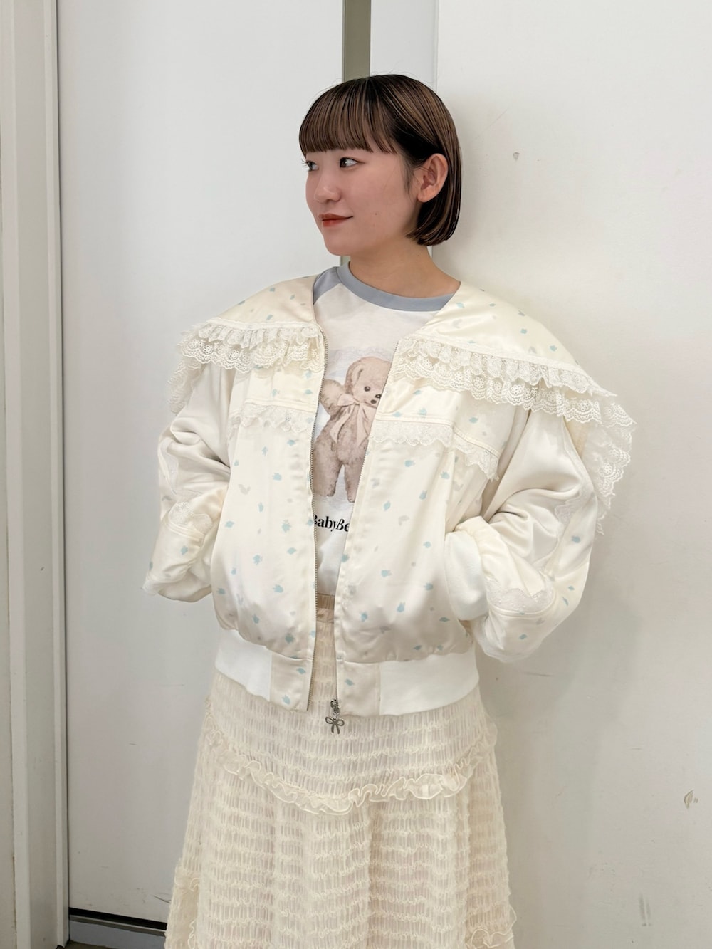 ブルー系のブルゾン、ブルー系のTシャツ/カットソー、ホワイト系のスカートを着用したレディースの夏コーディネートの4枚目の写真