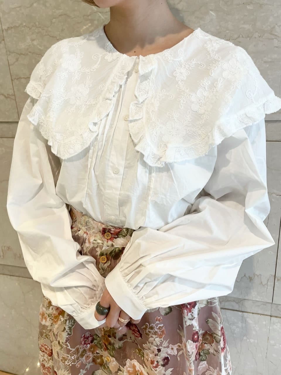 ピンク系のスカート、ホワイト系のパンプス、ホワイト系のシャツ/ブラウスを着用したレディースの夏コーディネートの4枚目の写真