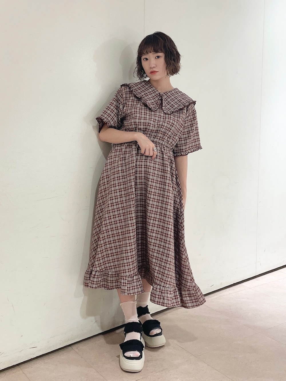 ブラック系のショルダーバッグ、レッド系のワンピース、ブラック系のサンダルを着用したレディースの夏コーディネートの2枚目の写真