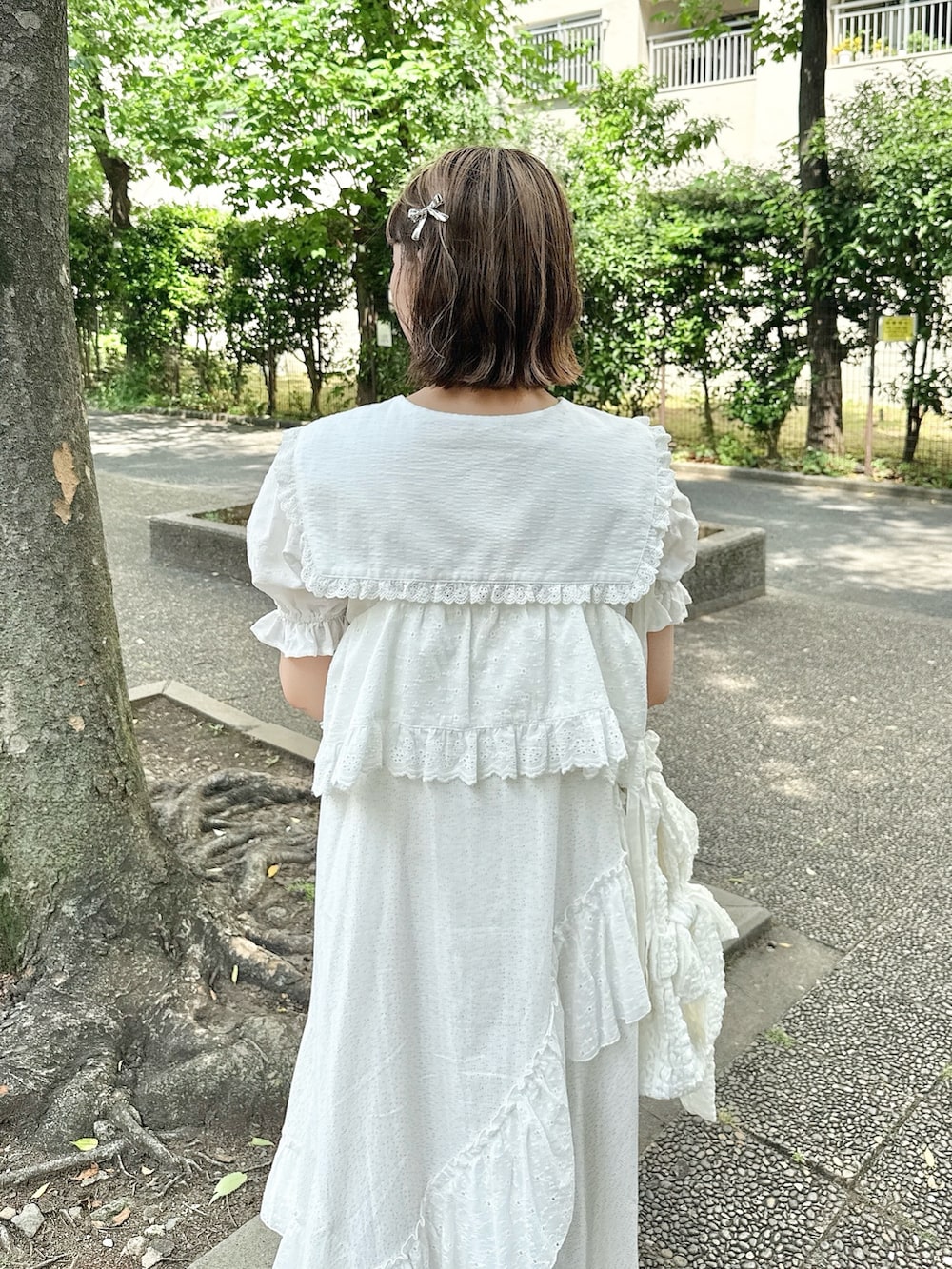 ホワイト系のシャツ/ブラウス、ホワイト系のサンダル、ホワイト系のトートバッグを着用したレディースの春コーディネートの6枚目の写真
