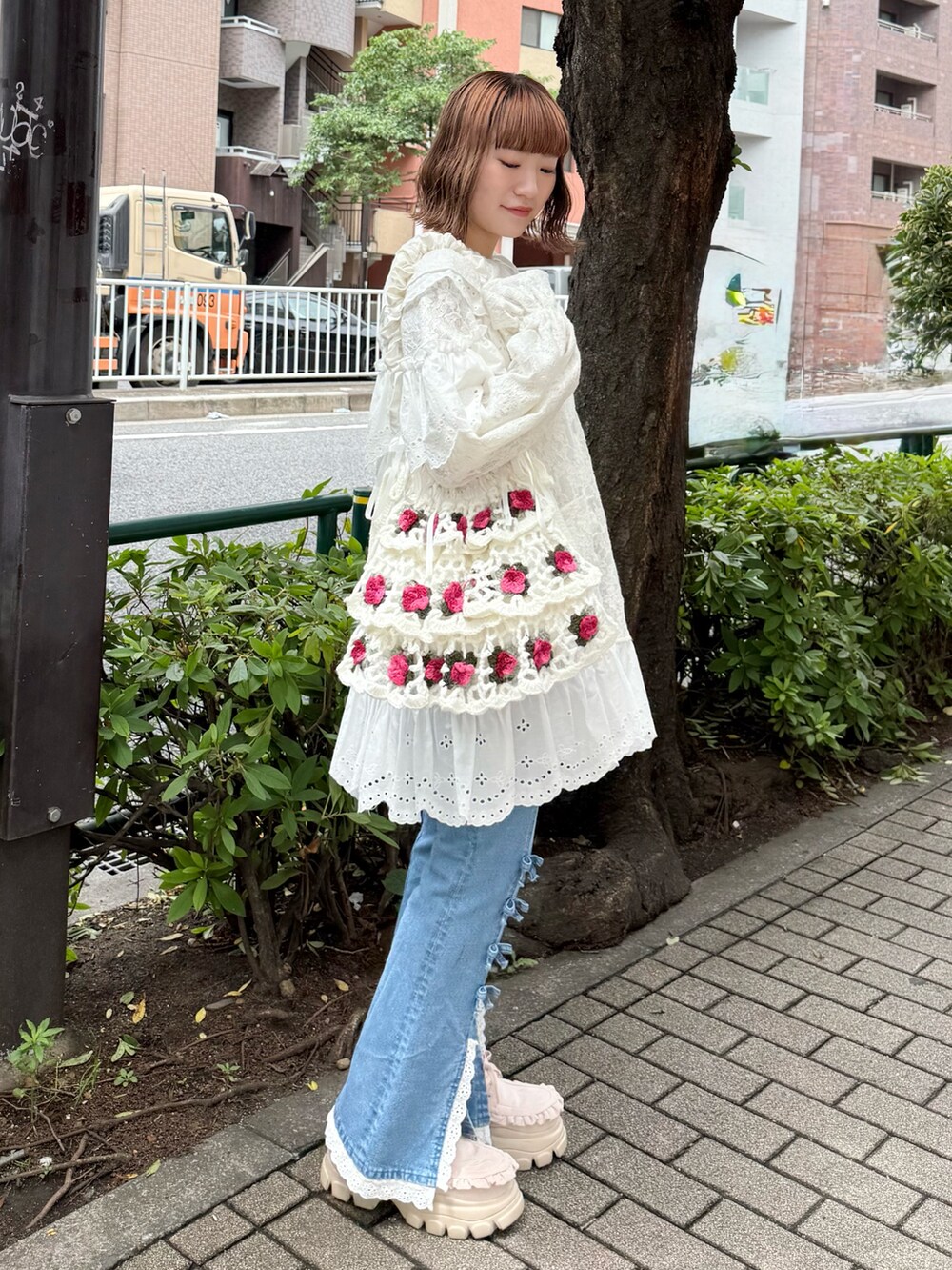ホワイト系のテーラードジャケット、ブルー系のデニムパンツ、ホワイト系のショルダーバッグを着用したレディースの夏コーディネートの3枚目の写真