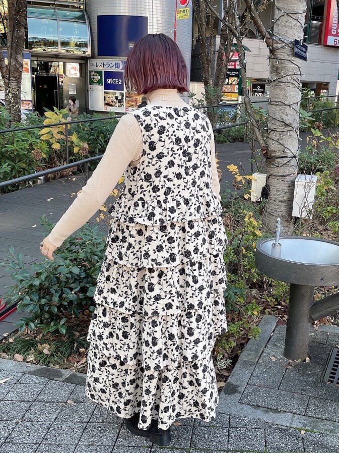 ブラック系のブーツ、ブラック系のナイロンジャケット、ホワイト系のジャンパースカートを着用したレディースの冬コーディネートの6枚目の写真