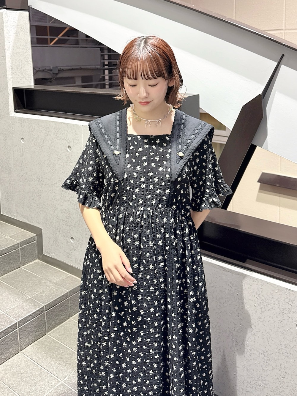 ブラック系のワンピース、ブラック系のスニーカー、ピンク系のネックレスを着用したレディースの春コーディネートの4枚目の写真