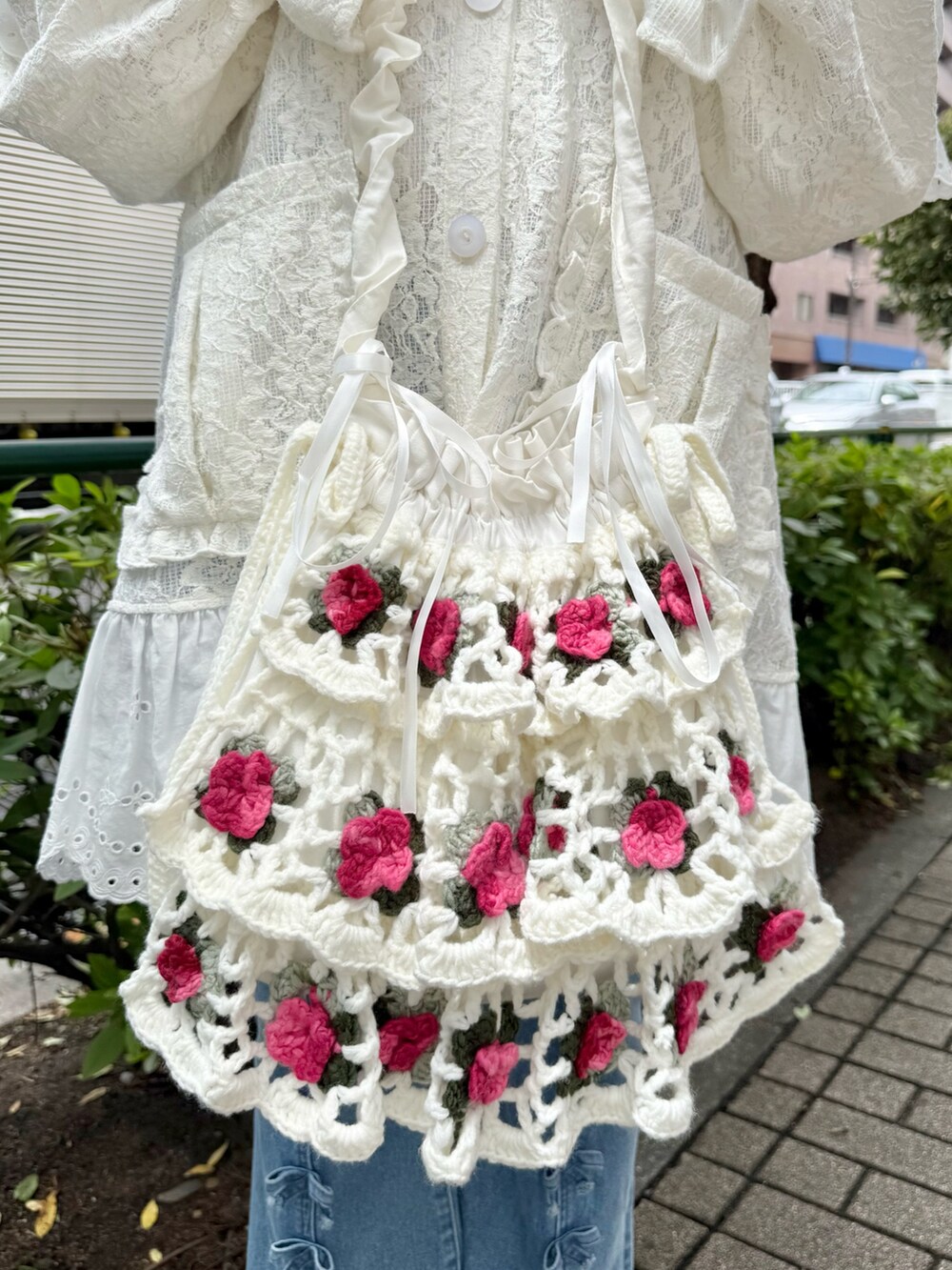 ホワイト系のテーラードジャケット、ブルー系のデニムパンツ、ホワイト系のショルダーバッグを着用したレディースの夏コーディネートの7枚目の写真