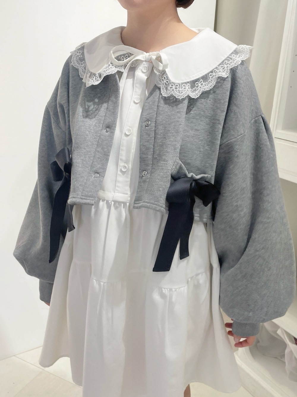 グレー系のカーディガン/ボレロ、ホワイト系のワンピース、ホワイト系のスニーカーを着用したレディースの冬コーディネートの6枚目の写真