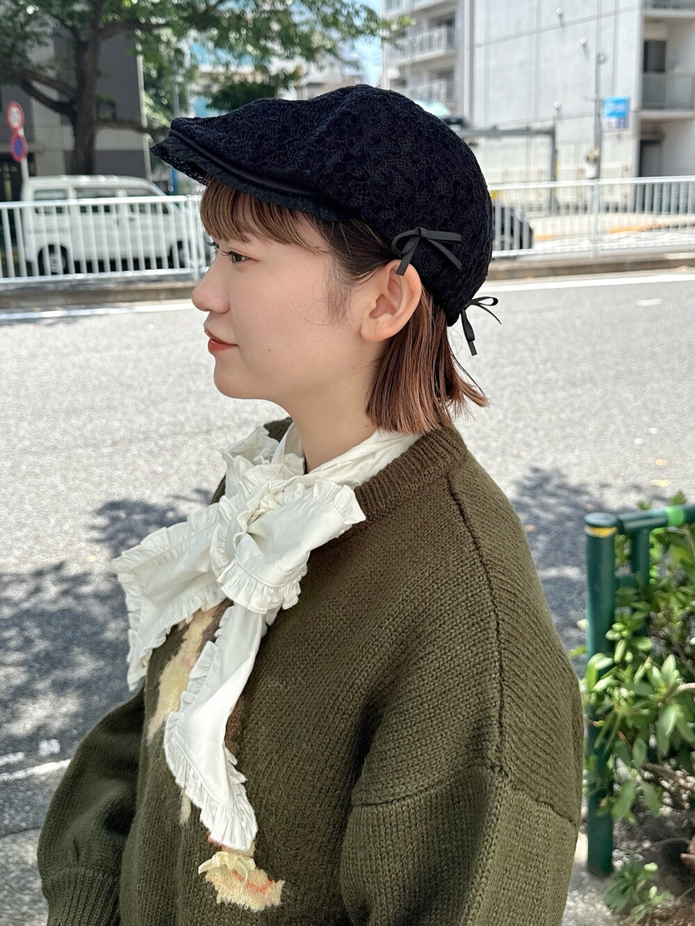 ホワイト系のシャツ/ブラウス、グレー系のショルダーバッグ、グリーン系のニット/セーターを着用したレディースの秋コーディネートの8枚目の写真