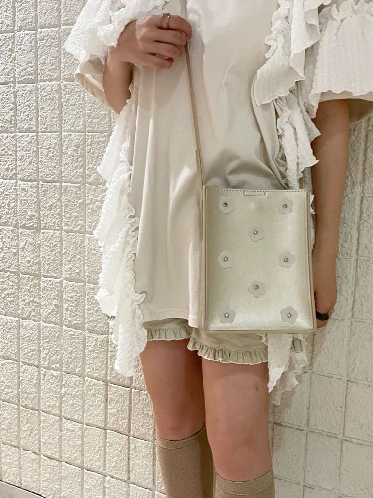 ホワイト系のチュニック、ホワイト系のその他パンツ、ゴールド系のショルダーバッグを着用したレディースの春コーディネートの6枚目の写真