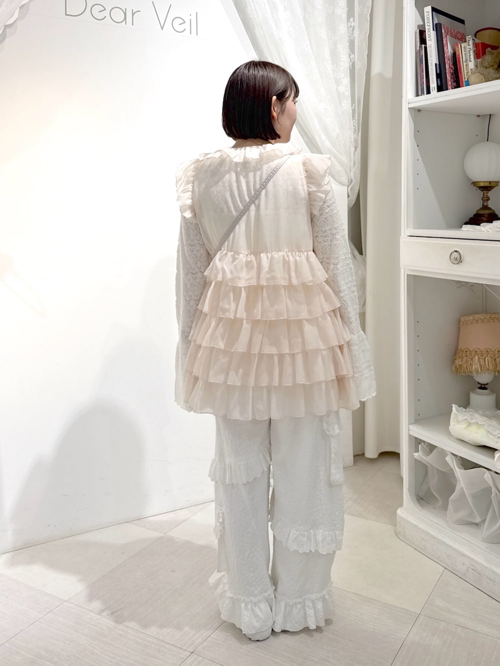 ピンク系のシャツ/ブラウス、ホワイト系のニット/セーター、ピンク系のハンドバッグを着用したレディースの夏コーディネートの3枚目の写真