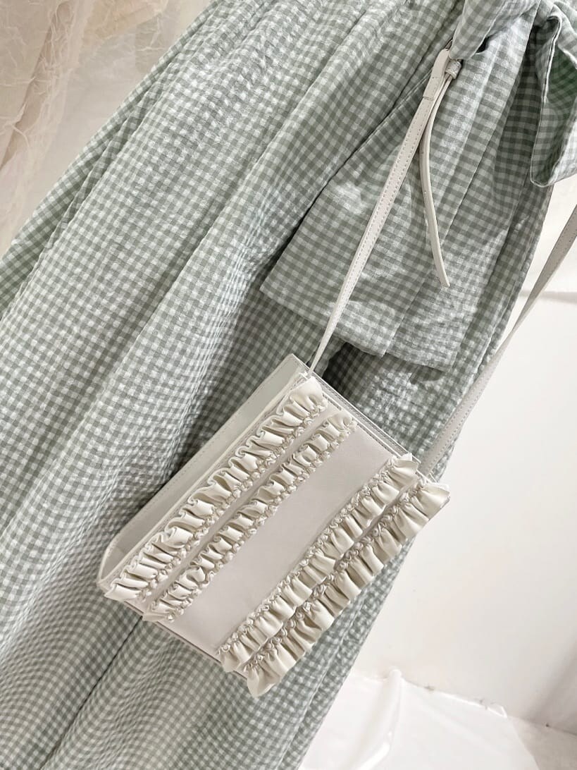 ホワイト系のサンダル、ホワイト系のショルダーバッグ、グリーン系のワンピースを着用したレディースの春コーディネートの5枚目の写真