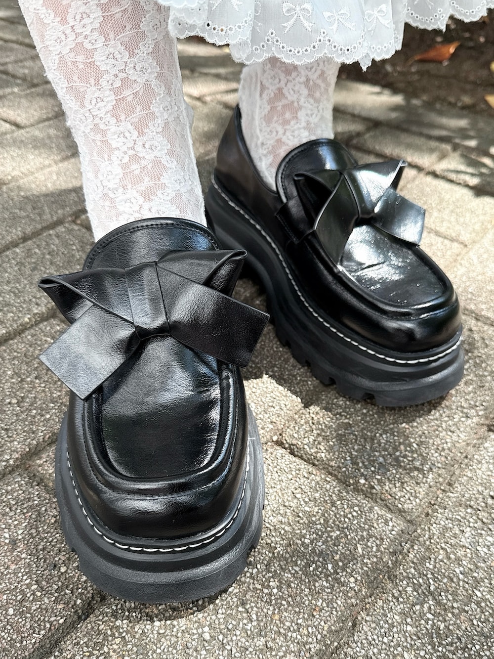 ホワイト系のカーディガン/ボレロ、ピンク系のハンドバッグ、ブラック系のローファーを着用したレディースの秋コーディネートの8枚目の写真