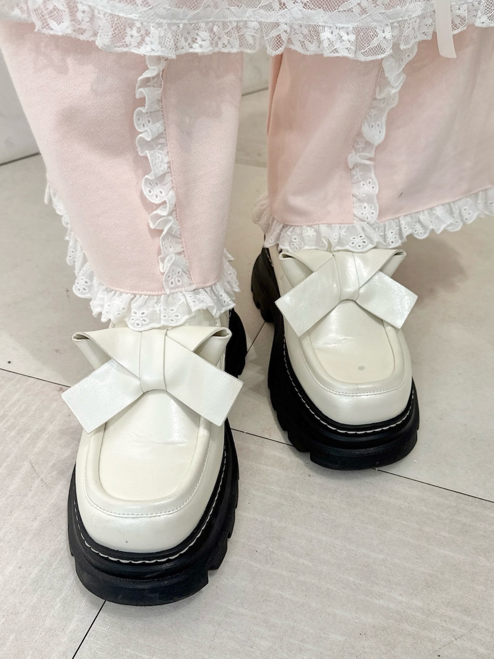 ホワイト系のスウェット、ホワイト系のスカート、ホワイト系のローファーを着用したレディースの冬コーディネートの7枚目の写真