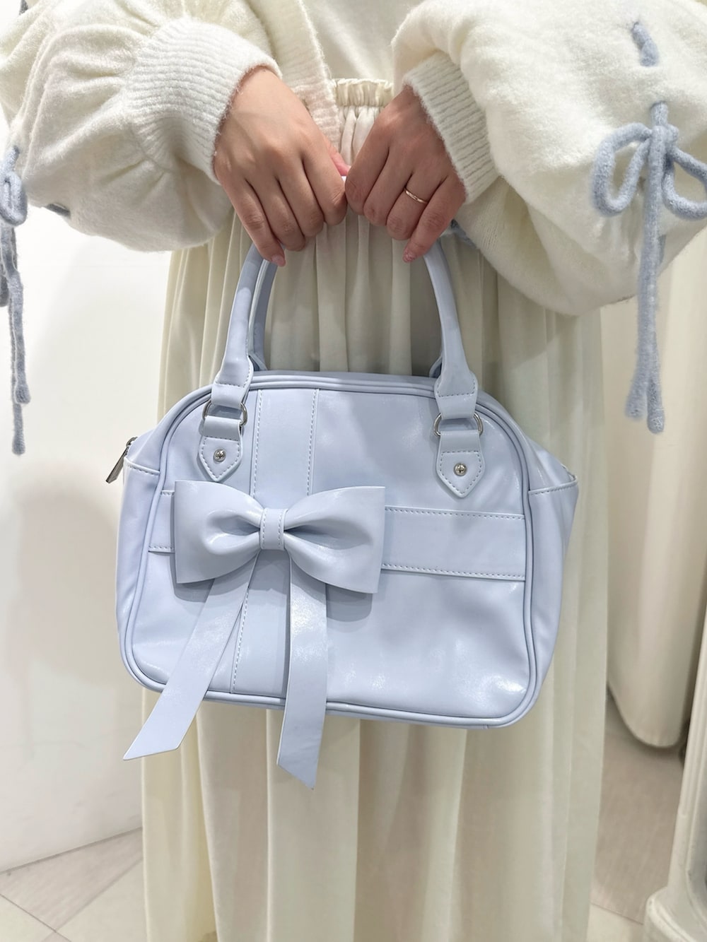 ホワイト系のワンピース、ホワイト系のカーディガン/ボレロ、ブルー系のハンドバッグを着用したレディースの秋コーディネートの9枚目の写真
