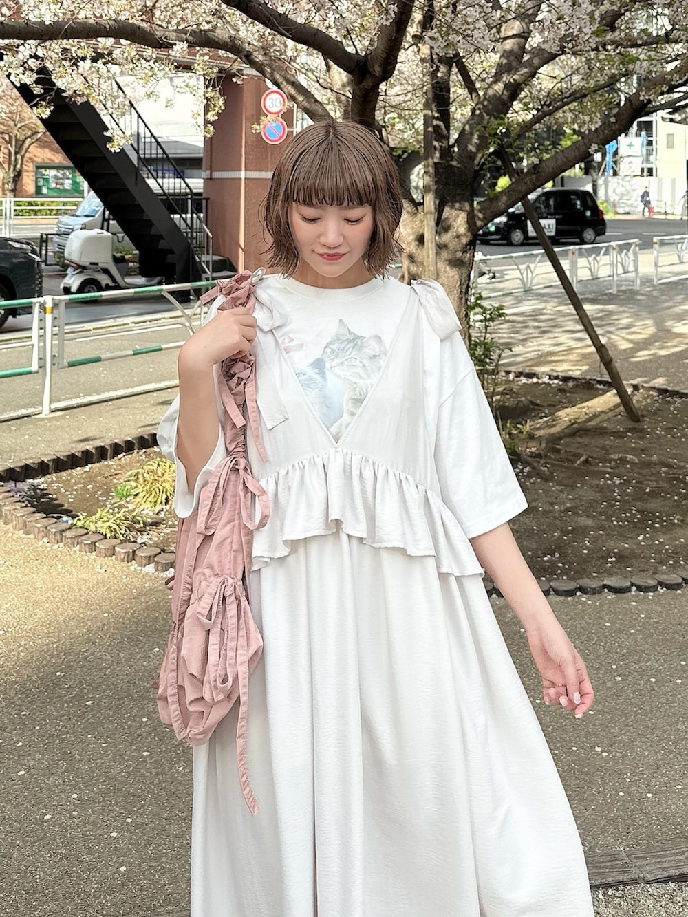 ホワイト系のTシャツ/カットソー、ホワイト系のワンピース、ピンク系のトートバッグを着用したレディースの春コーディネートの4枚目の写真