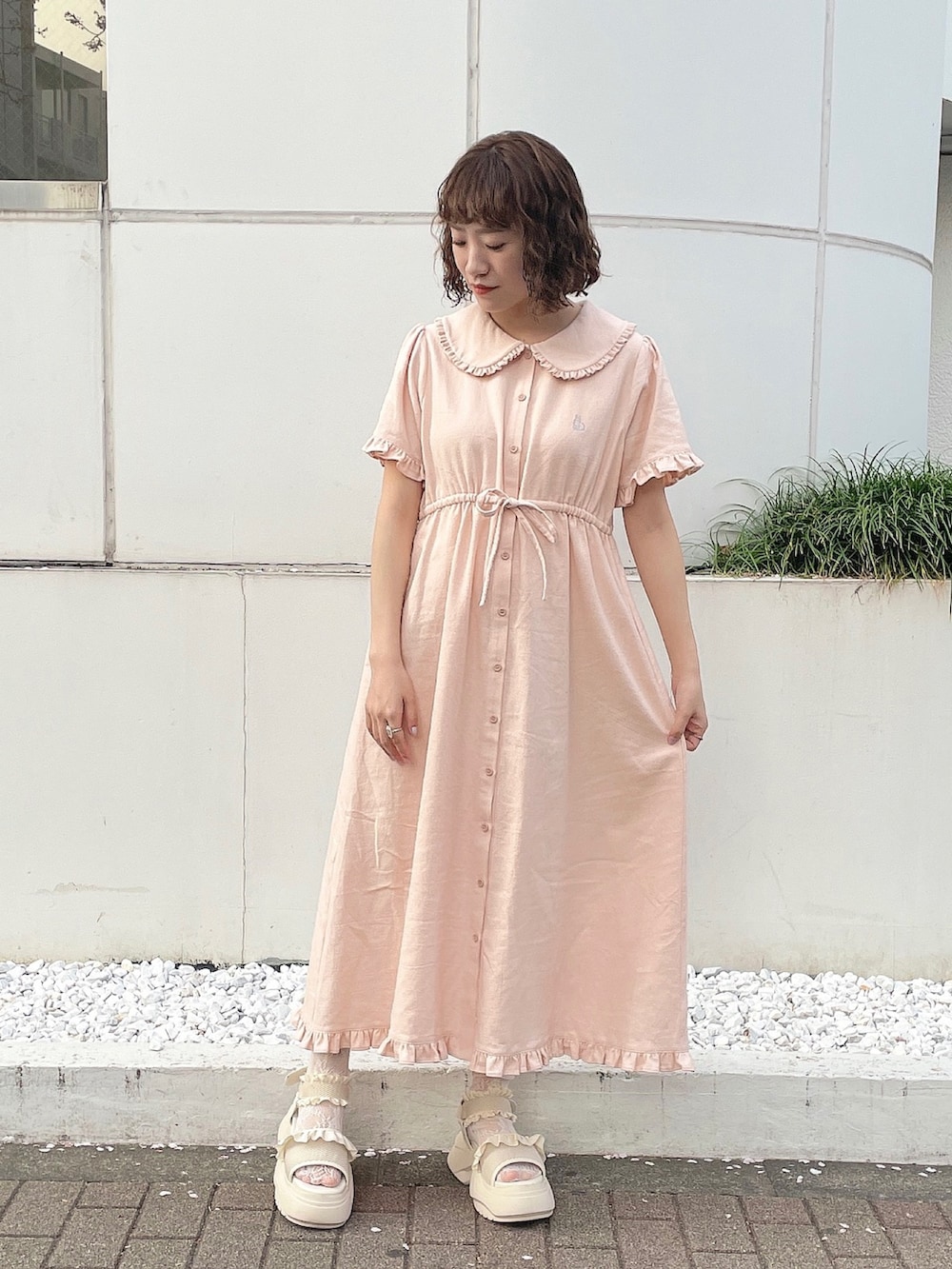 ベージュ系のシャツ/ブラウス、ピンク系のワンピース、ホワイト系のサンダルを着用したレディースの春コーディネートの4枚目の写真