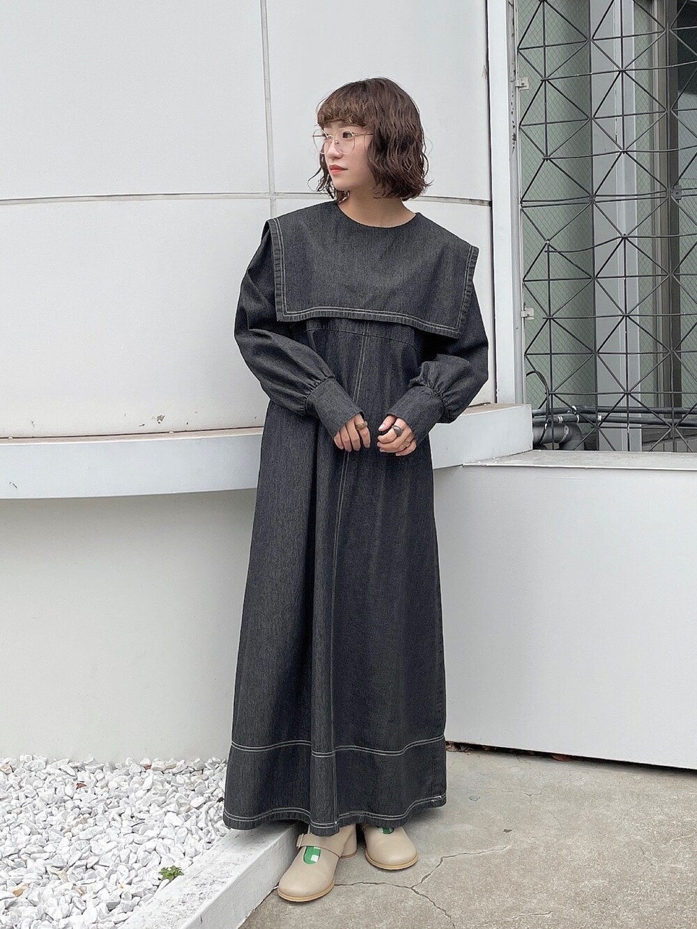 ブラック系のワンピース、ベージュ系のブーツを着用したレディースの冬コーディネートの2枚目の写真