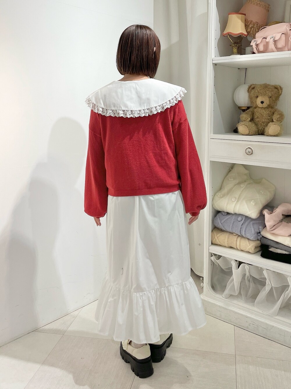 ホワイト系のワンピース、レッド系のカーディガン/ボレロ、ホワイト系のローファーを着用したレディースの秋コーディネートの3枚目の写真