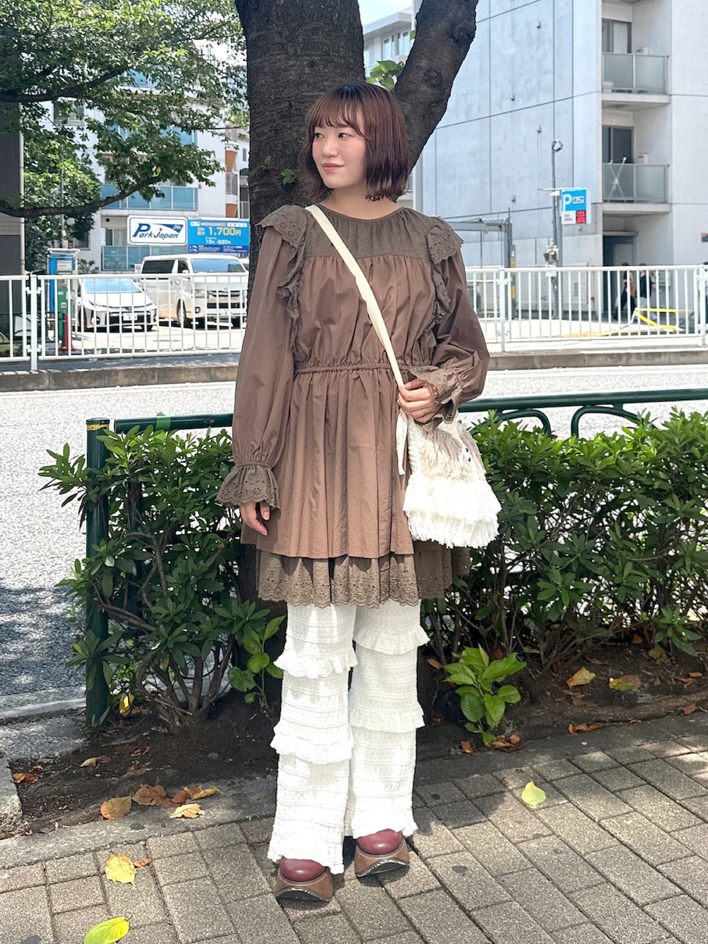 ブラウン系のワンピース、ベージュ系のショルダーバッグ、ホワイト系のその他パンツを着用したレディースの夏コーディネートの2枚目の写真