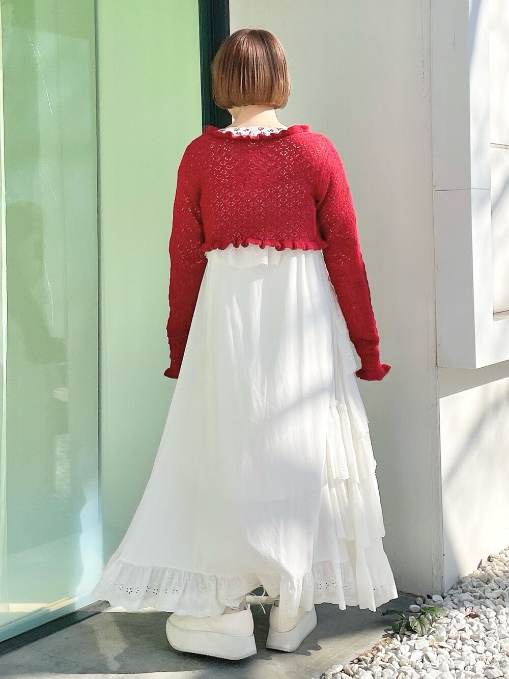 ピンク系のTシャツ/カットソー、レッド系のカーディガン/ボレロ、ホワイト系のワンピースを着用したレディースの冬コーディネートの3枚目の写真
