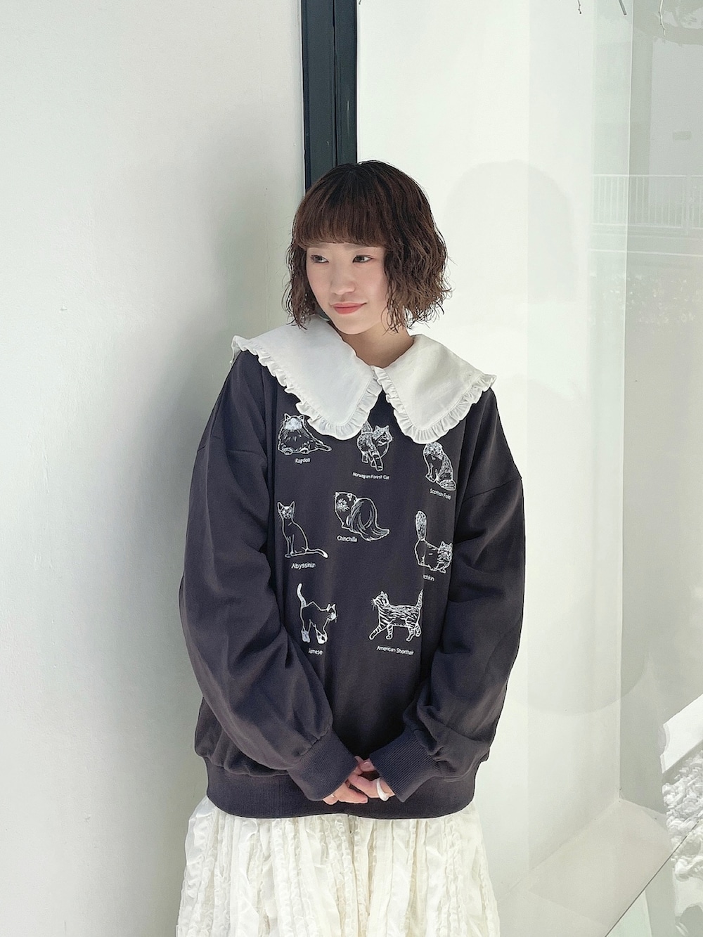 グレー系のスウェット、ホワイト系のワンピース、ホワイト系のスカートを着用したレディースの夏コーディネートの3枚目の写真