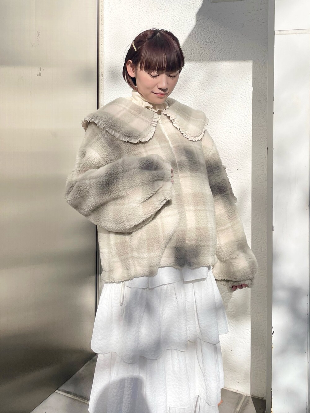 ホワイト系のスカート、ベージュ系のブルゾン、ホワイト系のニット/セーターを着用したレディースの冬コーディネートの4枚目の写真