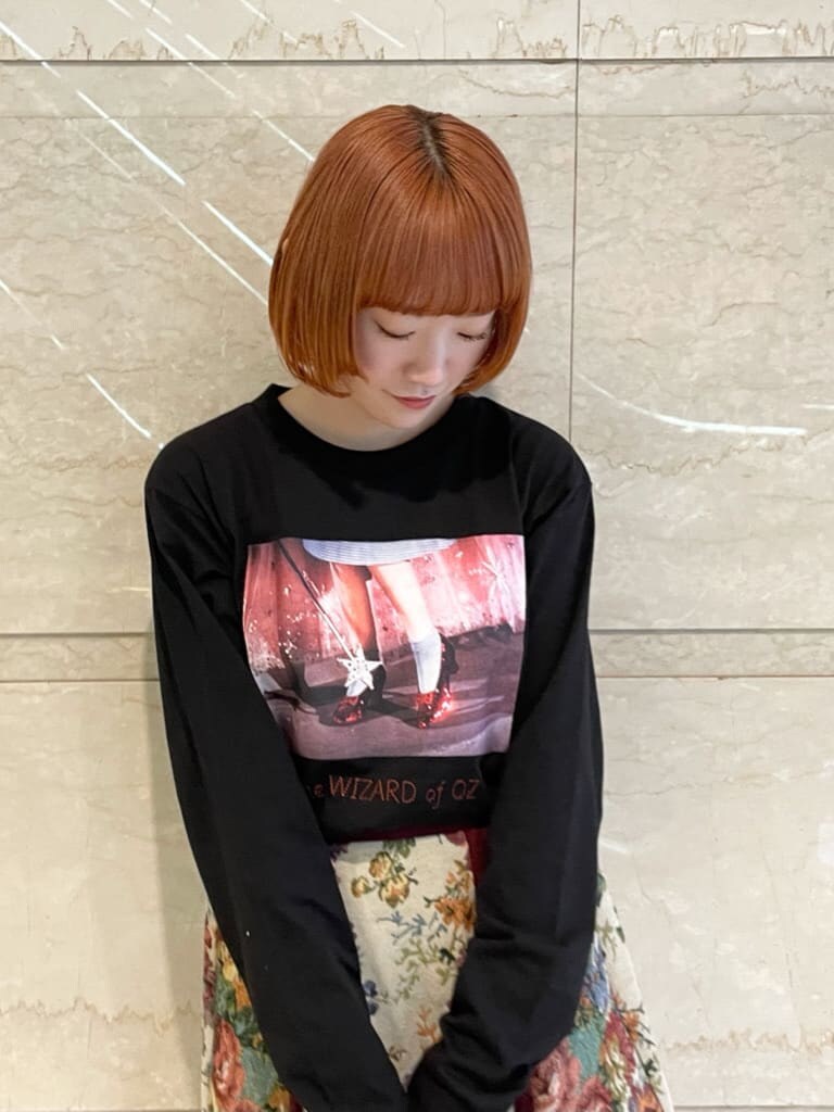 ブラック系のTシャツ/カットソー、レッド系のスカート、ブラック系のスニーカーを着用したレディースの秋コーディネートの3枚目の写真