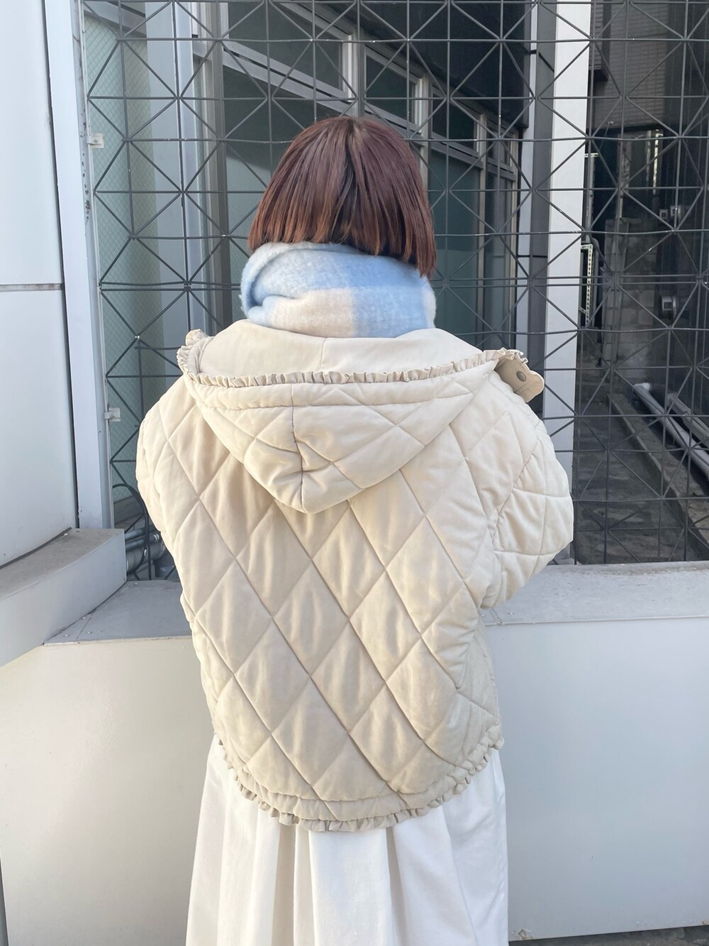 ホワイト系のダウンジャケット/コート、ホワイト系のワンピース、ホワイト系のスニーカーを着用したレディースの冬コーディネートの6枚目の写真