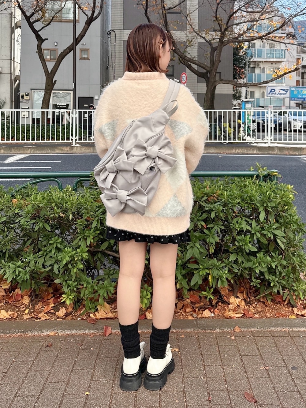 ピンク系のニット/セーター、グレー系のショルダーバッグ、ブラック系のスカートを着用したレディースの冬コーディネートの3枚目の写真