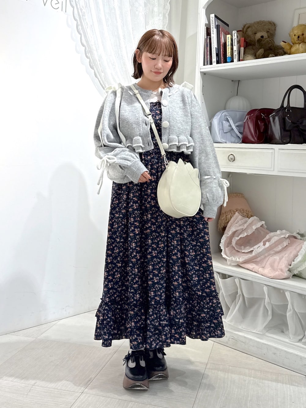 グレー系のカーディガン/ボレロ、ホワイト系のTシャツ/カットソー、ホワイト系のショルダーバッグを着用したレディースの秋コーディネートの2枚目の写真