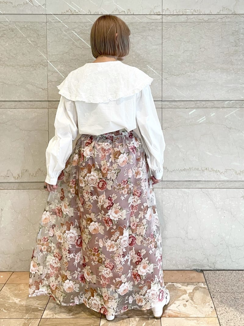 ピンク系のスカート、ホワイト系のパンプス、ホワイト系のシャツ/ブラウスを着用したレディースの夏コーディネートの2枚目の写真