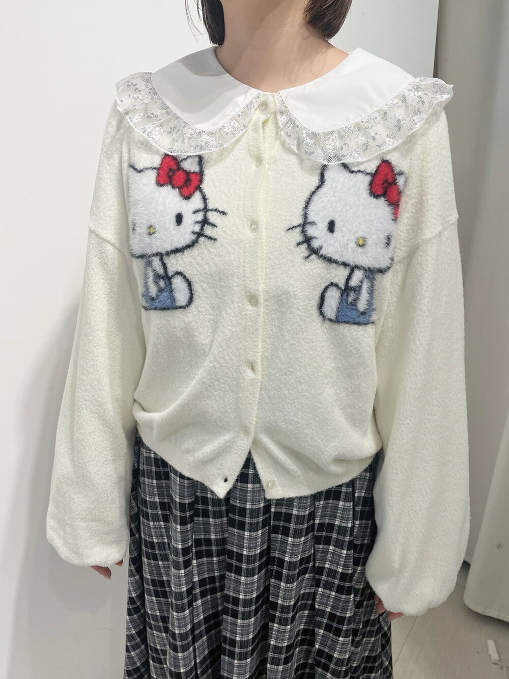 ホワイト系のカーディガン/ボレロ、シルバー系のシャツ/ブラウス、ブラック系のスカートを着用したレディースの秋コーディネートの6枚目の写真