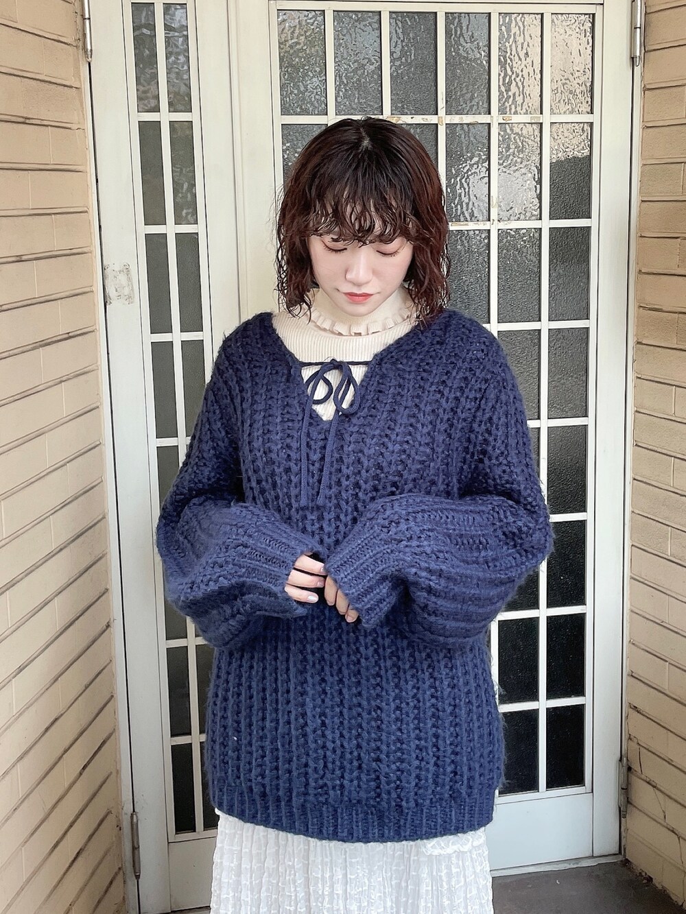 ブルー系のニット/セーター、ホワイト系のニット/セーター、ホワイト系のスカートを着用したレディースの秋コーディネートの4枚目の写真