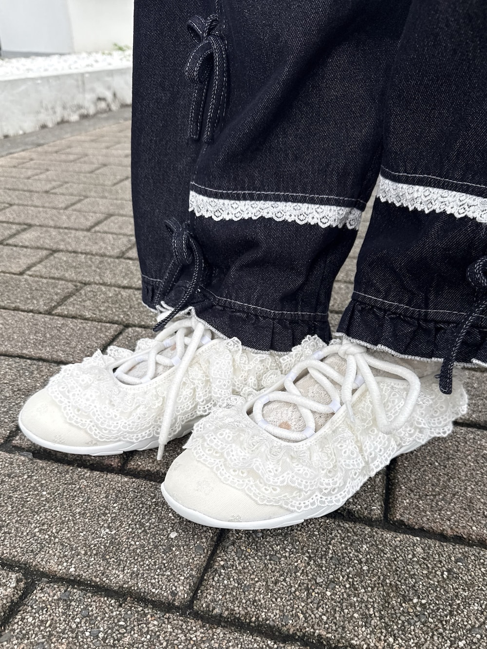 ブルー系のデニムパンツ、ホワイト系のスニーカー、ホワイト系のスカートを着用したレディースの夏コーディネートの7枚目の写真