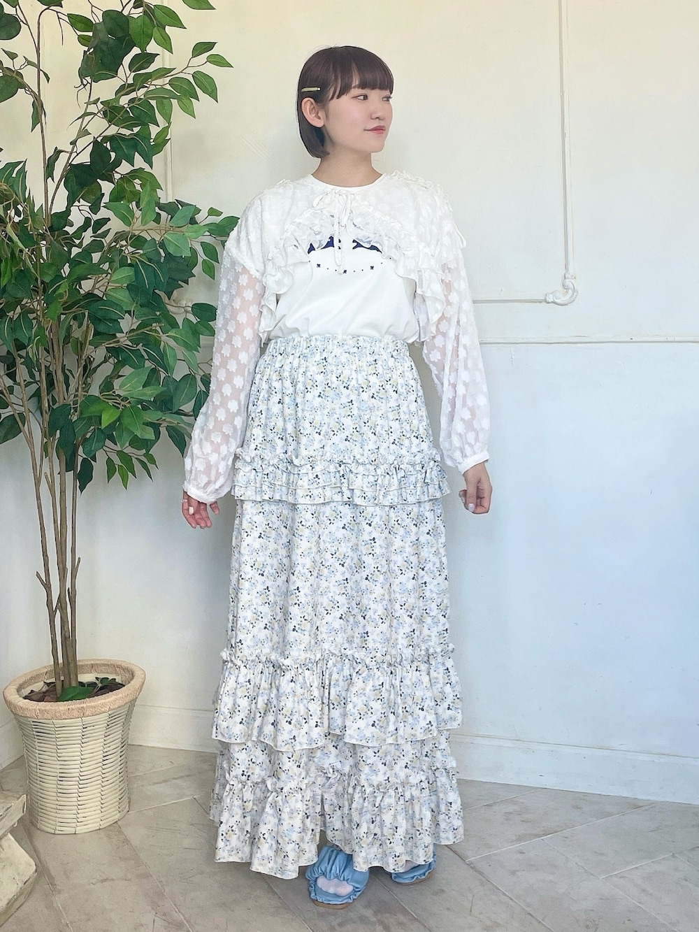 イエロー系のスカート、ブルー系のサンダル、ホワイト系のTシャツ/カットソーを着用したレディースの春コーディネートの2枚目の写真